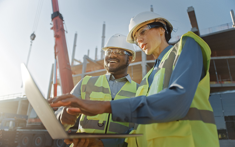 Construction workers use a computer