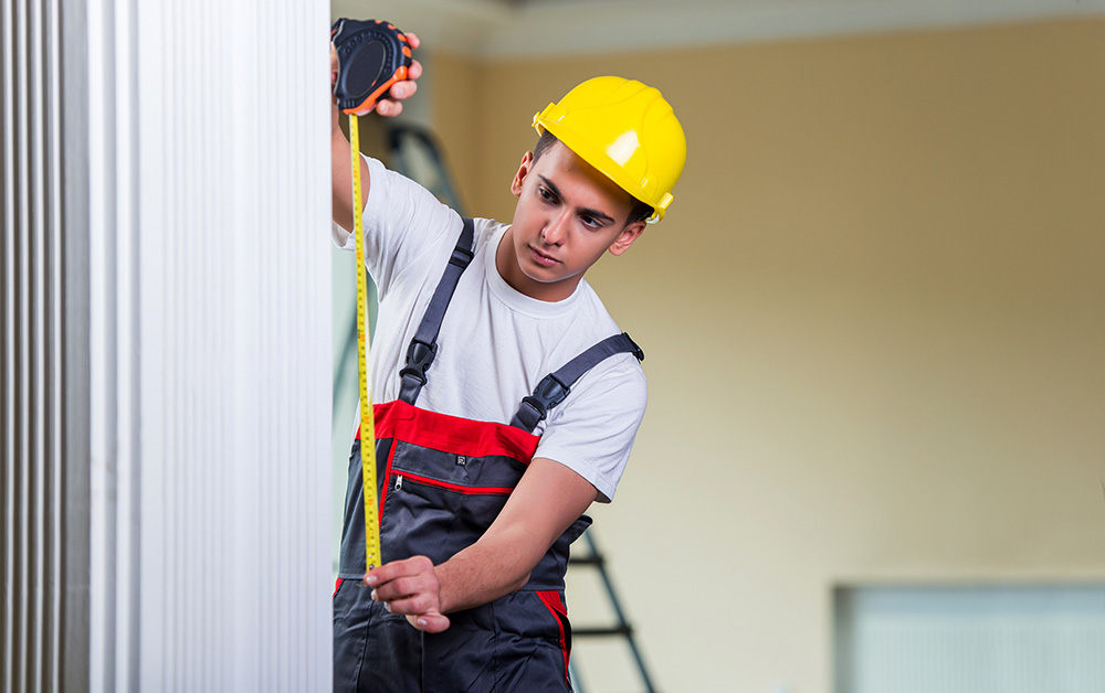 A construction worker measures