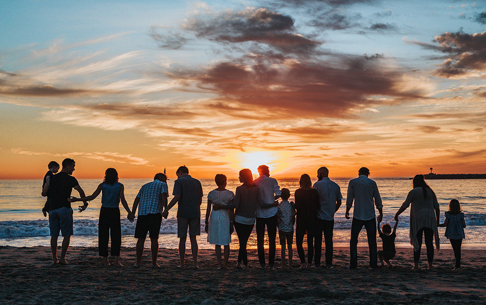 Large family watches sunset on the beach