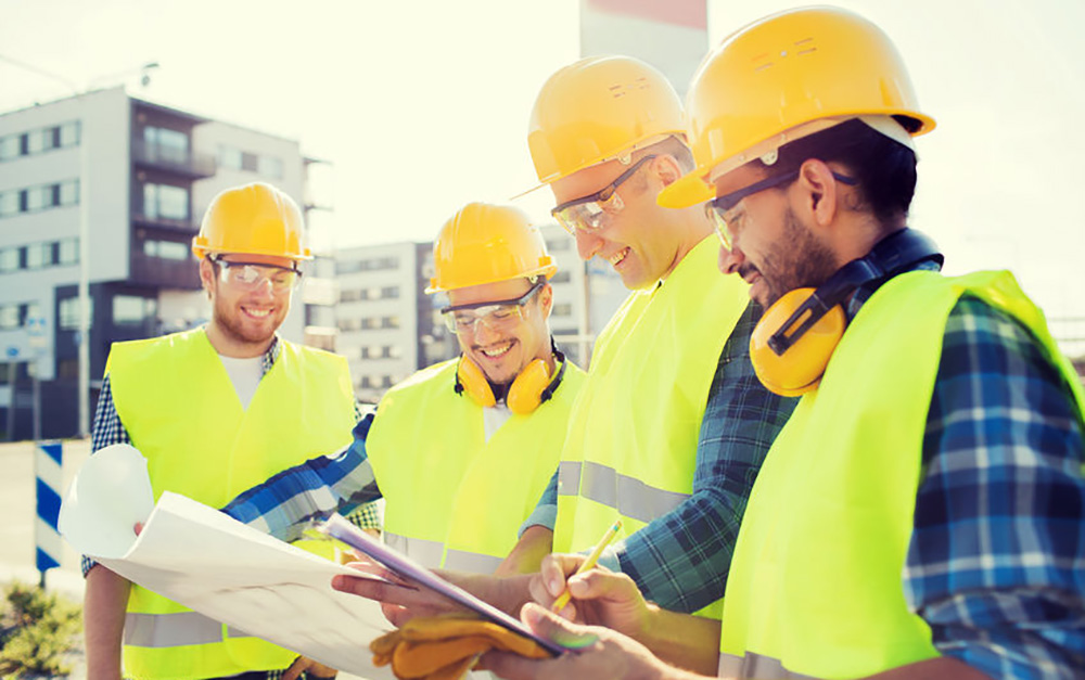 Construction workers smiling over plans