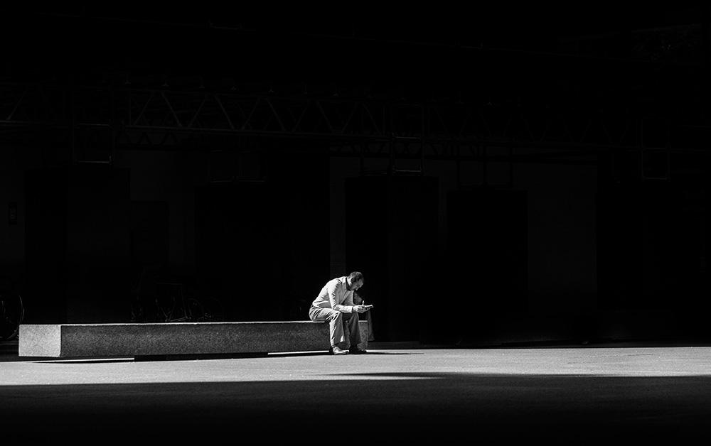 Man sits alone in stark light