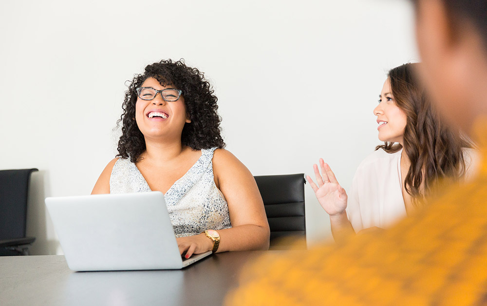 Coworkers laugh at a table