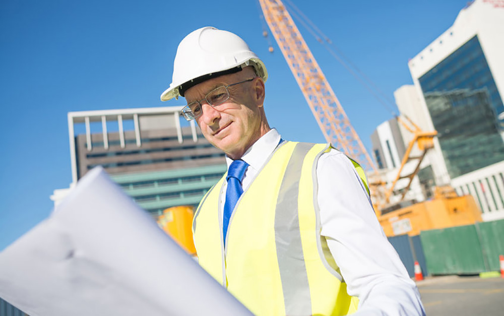 Man looks at blueprints on a construction site
