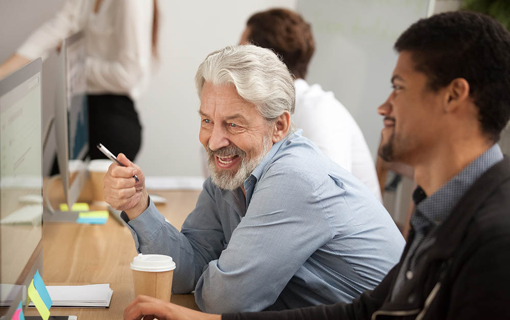 Colleagues have a meeting by a computer