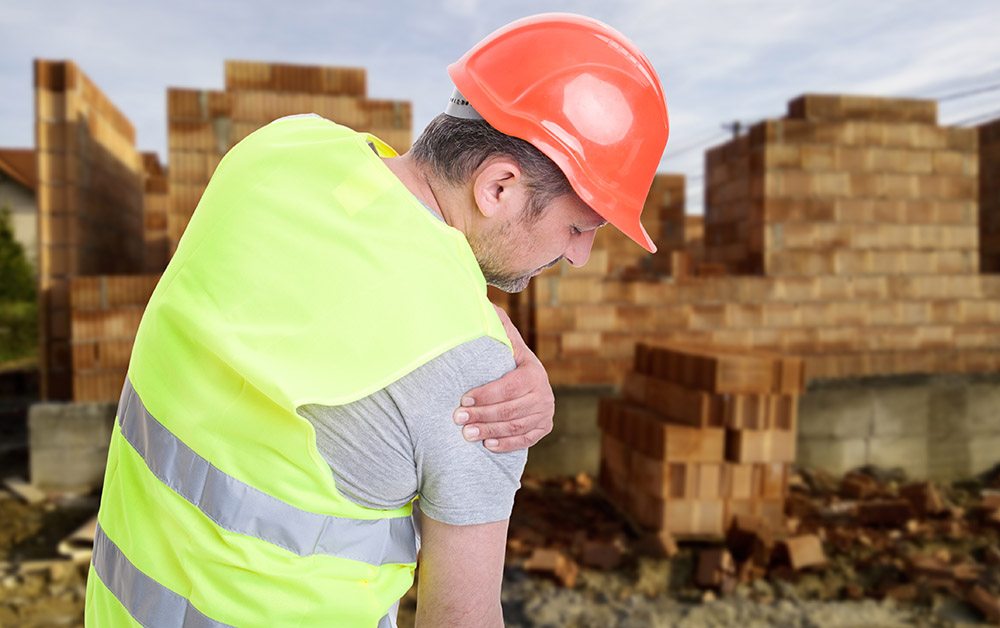 A construction worker tends to his hurt shoulder