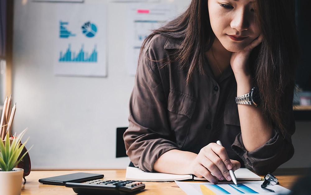 A woman works on financial documents