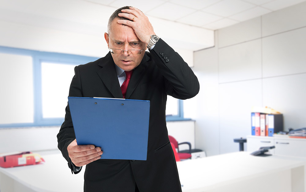 A worried business man looks at a document.